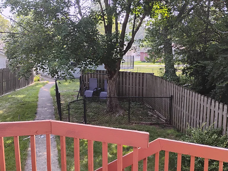 balcony view of backyard entryway with fenced-in swing towards garage