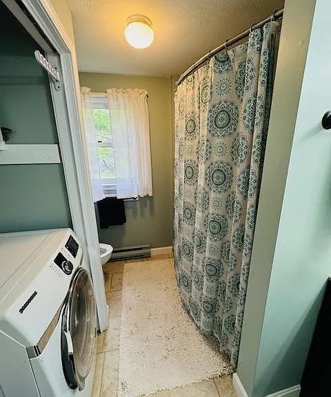 Full bathroom with washer and dryer.