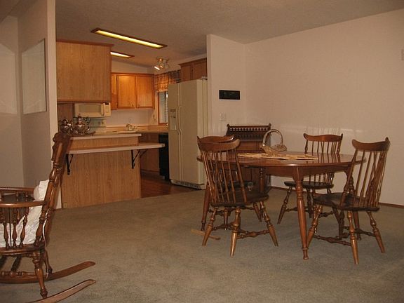 Looking towards kitchen featuring a lower eating bar and laminate flooring for easy clean up.