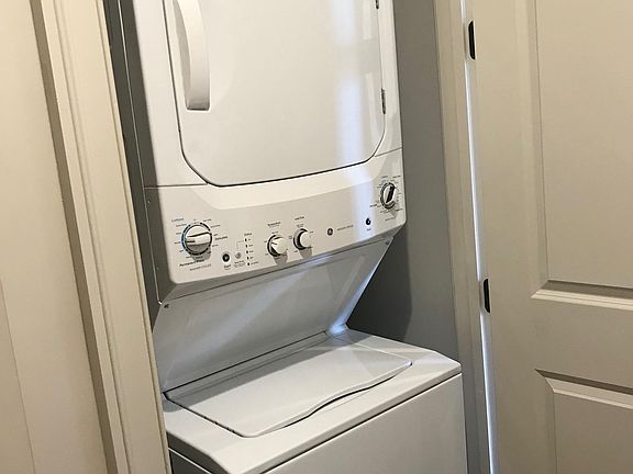 Stacked washer/dryer in unit