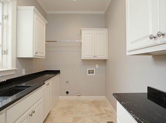 Spacious tile floor utility room with sink