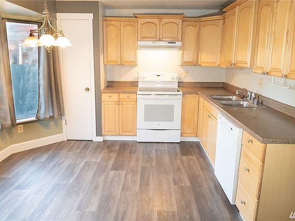 Eat-in kitchen with warm toned cabinetry.