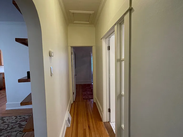 Hallway to bedroom, full bathroom and family room.