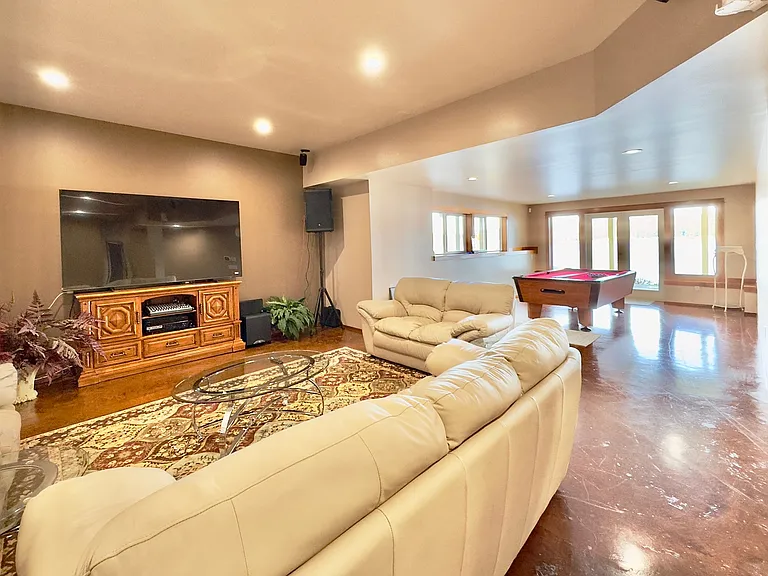 The entertainment lounge is the highlight_featuring an impressive 85" TV, a pool table, and cozy seating for gatherings. Direct access to the patio and beach seamlessly connects indoor comfort with outdoor adventure.