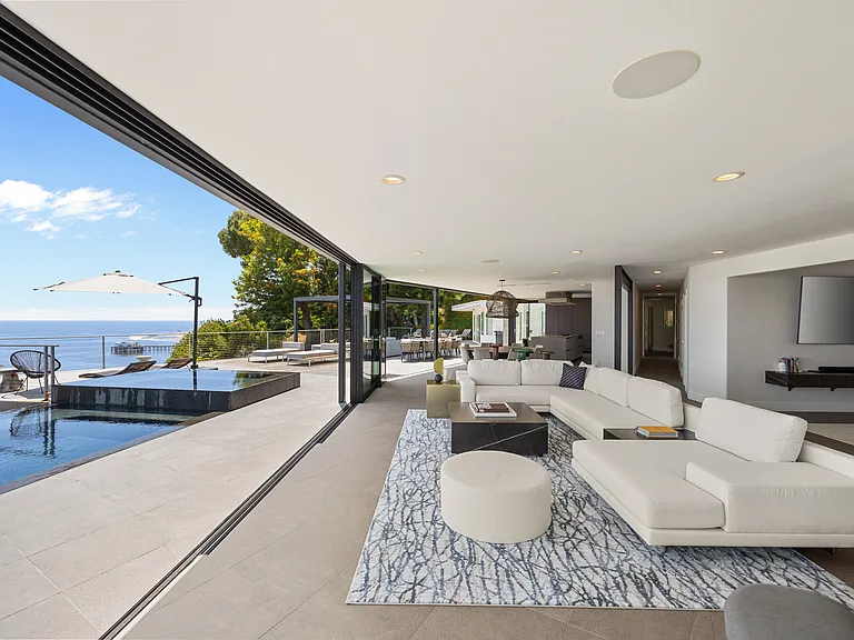 The living room is designed for relaxation and entertainment against a backdrop of endless sea.