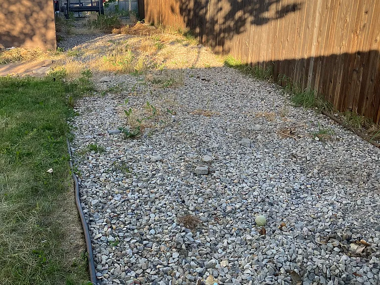 Gravel leading to front of house with gate
