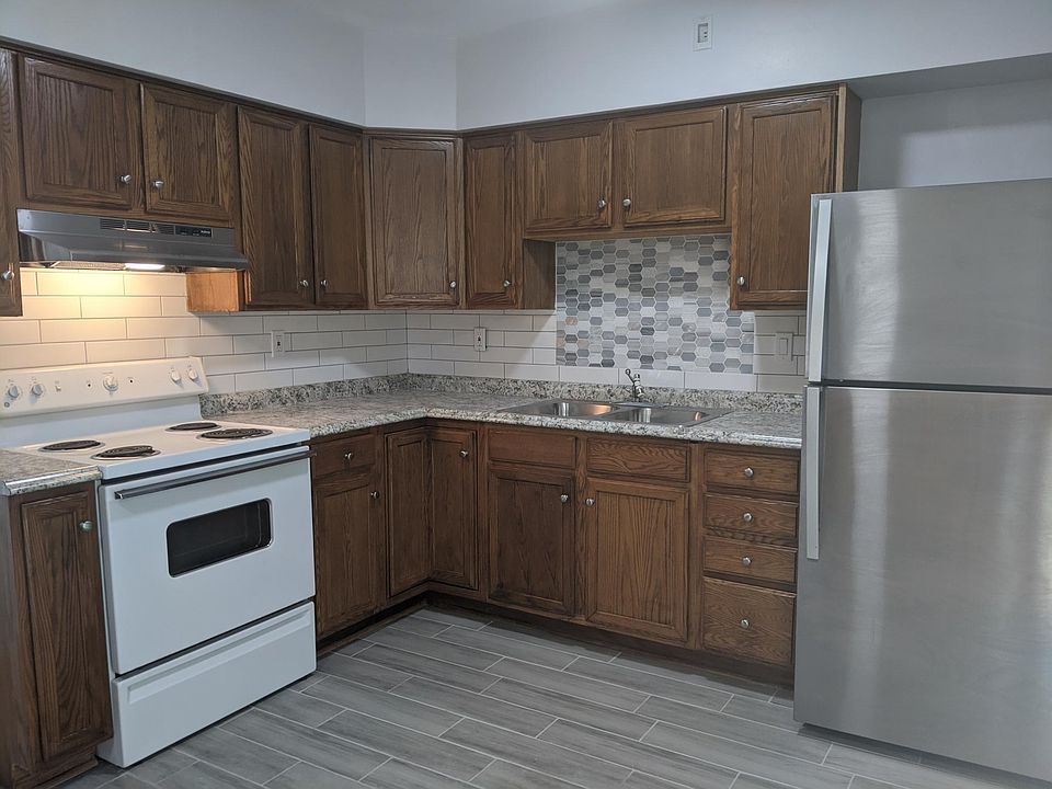 Kitchen with new sink and refrigerator. New backsplash with subway tile and mosaic glass tiles. Range will be replaced with a stainless steel glass top before move in.