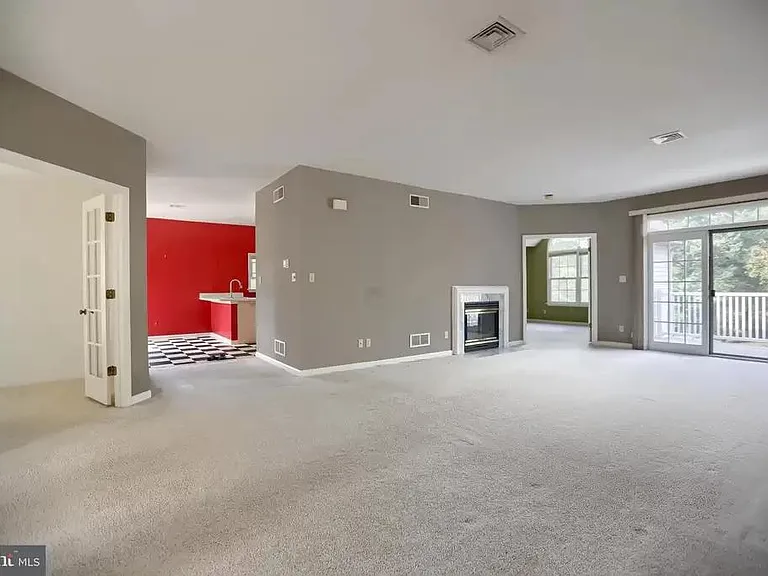 Living room with fireplace and view of office to the left, kitchen, baster suite and step into the balcony.