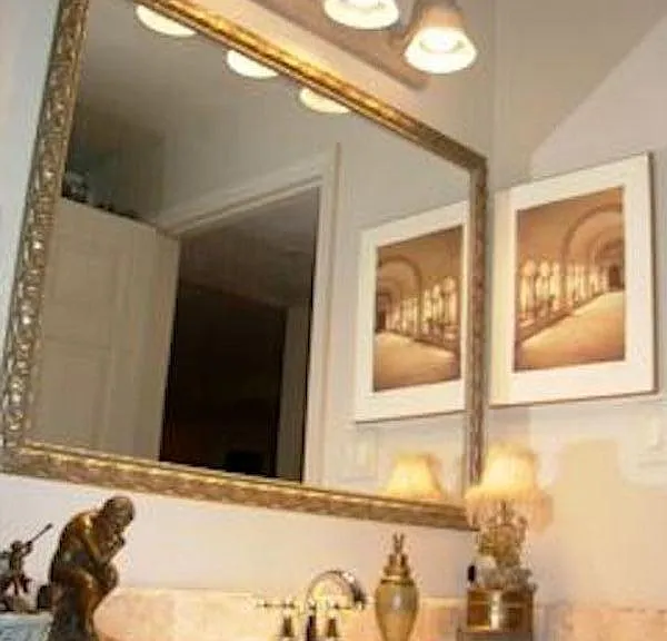 Front full bathroom travertine counter, framed mirror, lights