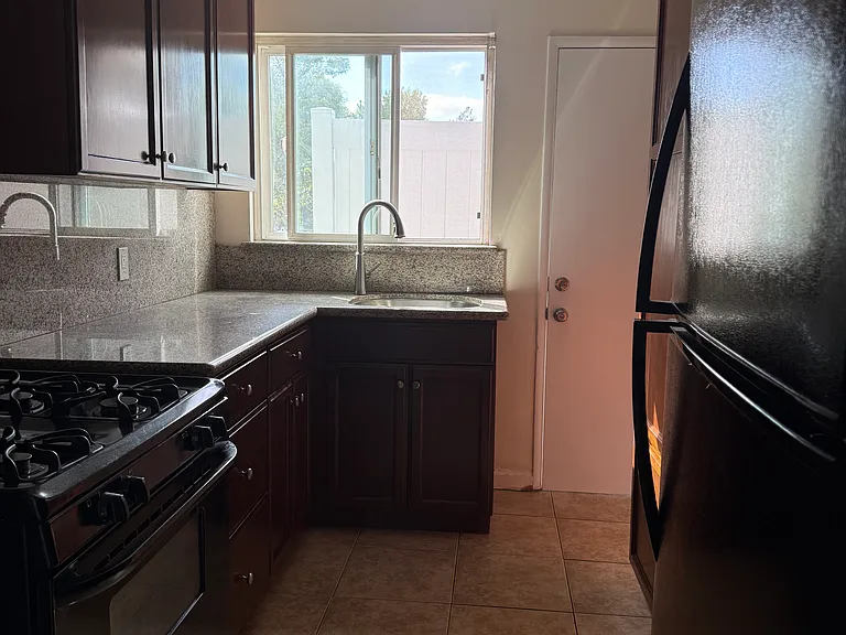 Kitchen view of sink and window and door leading to sitting balcony
