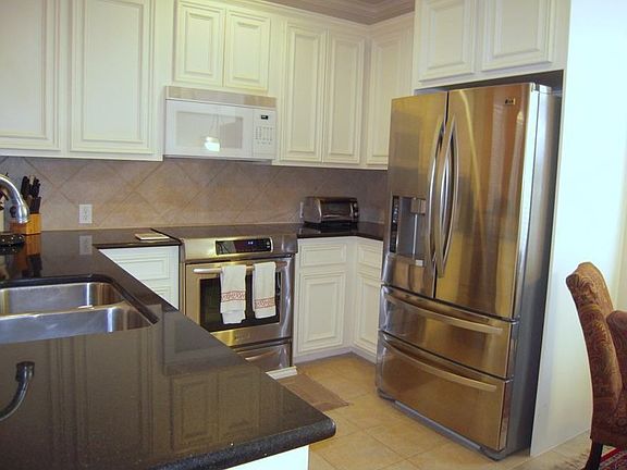 Kitchen with granite counters, tile floors and stainless convection oven.
