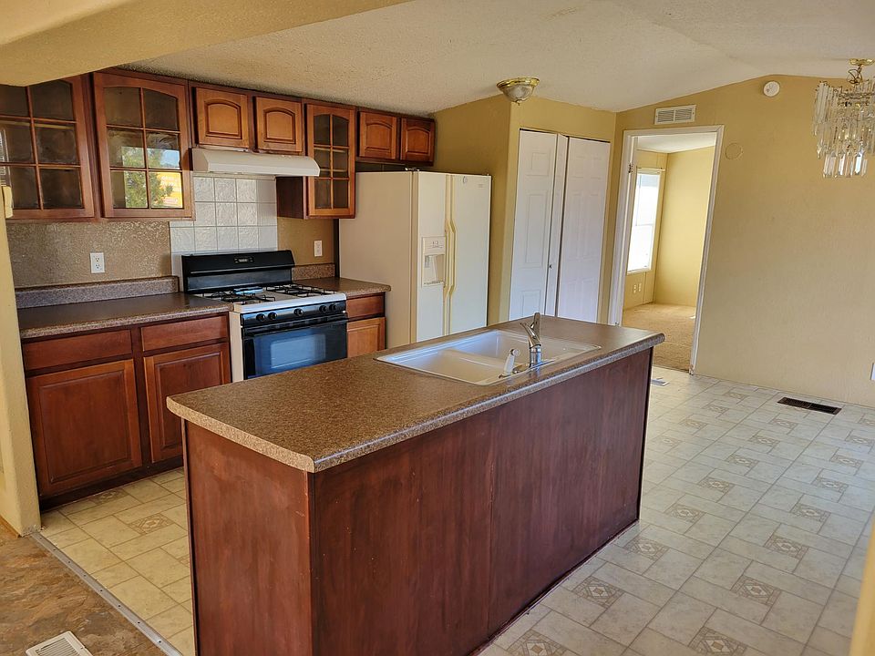 Kitchen w/island equipped with stove and refrigerator