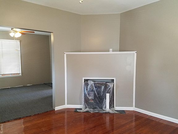 Large living room with hardwood floors, windows, ceiling fan and new fireplace insert