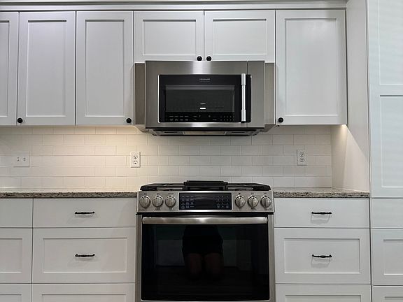 Stainless appliances; custom cabinets with built-ins; granite countertops;