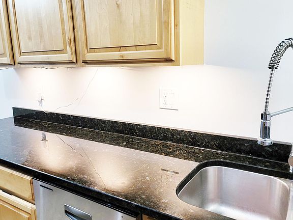 Kitchen features nice layout, including granite countertop, pull down sink, wooden cabinets, and more.