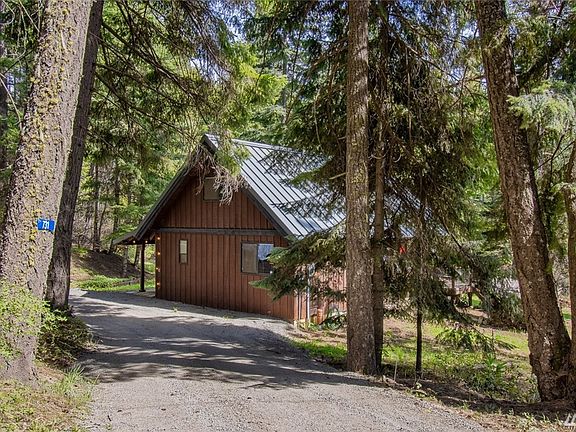 Private drive to the home that is surrounded by the best of the area with well established evergreen fir and pine trees.