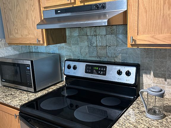 Kitchen features stainless appliances and lots of custom oak cabinets. Microwave included.