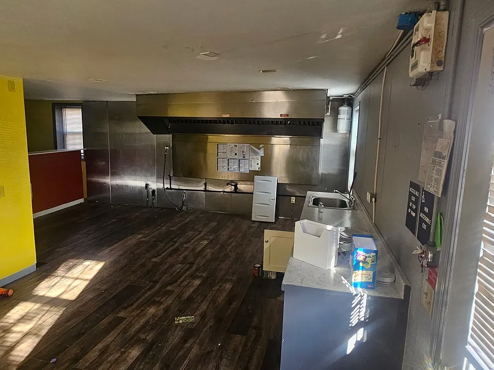 Back room with sink/water hookups and space for storage or a work area.