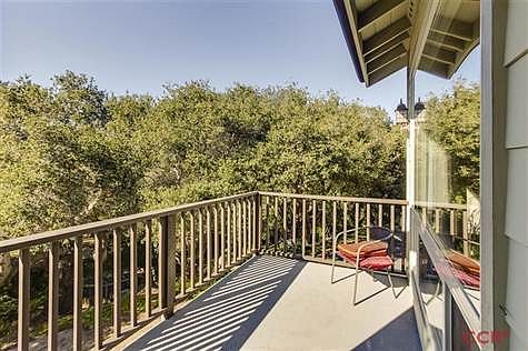 Deck off of living room overlooking open space.