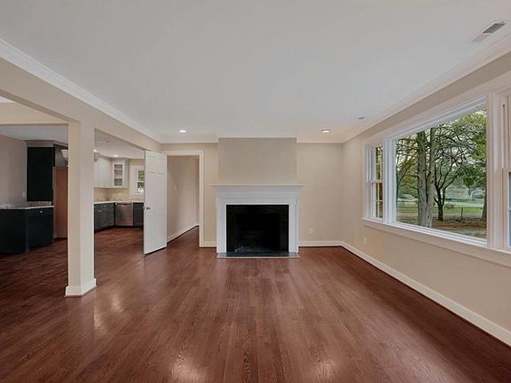 View from foyer into formal living room with recessed lighting, fireplace and HUGE windows for natural lighting!