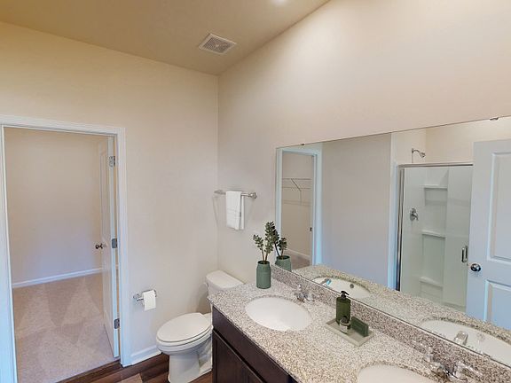 Owner s suite bath with dual vanities and a spacious walk-in closet. - Model Representation