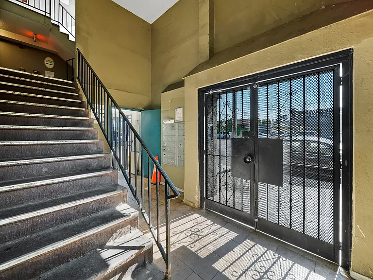 Gated building entry featuring controlled access and stairway access to upper levels.