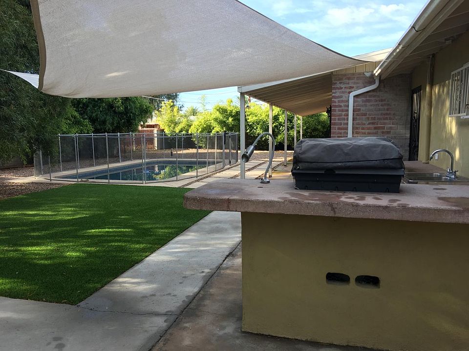 Outdoor bbq area with double sink, lots of counter space and high top counter for bar stools & bankette seating for fire pit