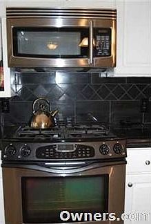 Stainless stove and microwave showing granite design