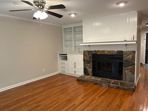 Living room with built-ins and electric fireplace, sliding glass doors to deck and outside storage