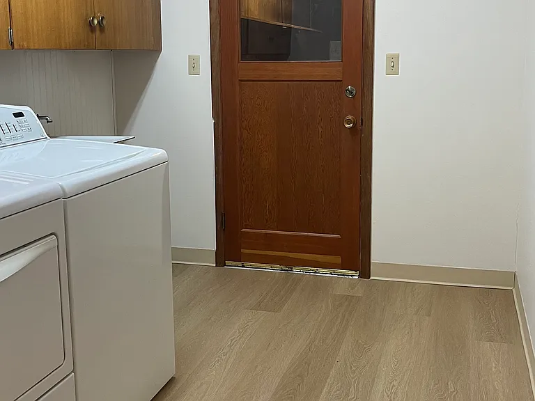 Large laundry room with generous cabinet storage. Door leading to two car garage. Garage includes 30 amp outlet that could be used for EV charging. Bring your own charger.