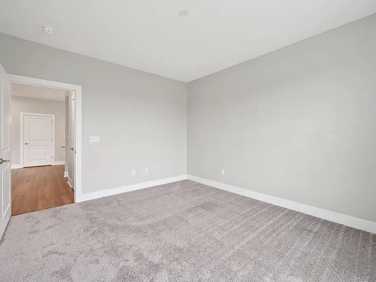 Dooley's Orchard apartment unit showing a bedroom carpeted floor and a doorway.