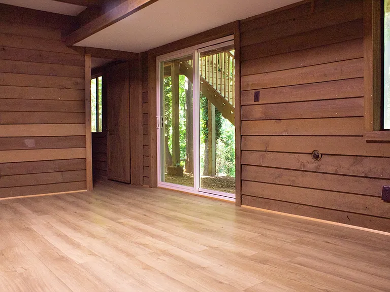 The main room in the basement features a sliding glass door and a window.