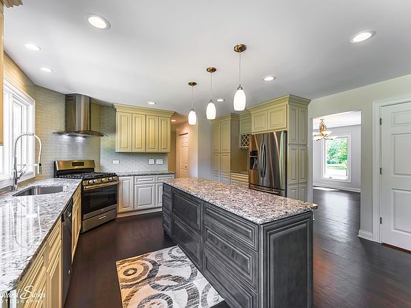 Incredible kitchen...quartz, stainless steel appliances, stainless range hood, glass backsplash.