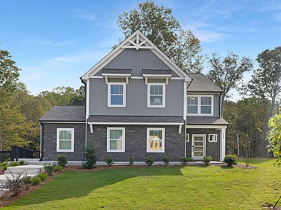 A rendering of a house with a garage and a lot of windows.