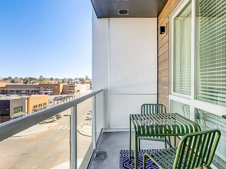 Take in the view from a private balcony featuring contemporary seating, glass railings, and easy access to indoor living spaces.