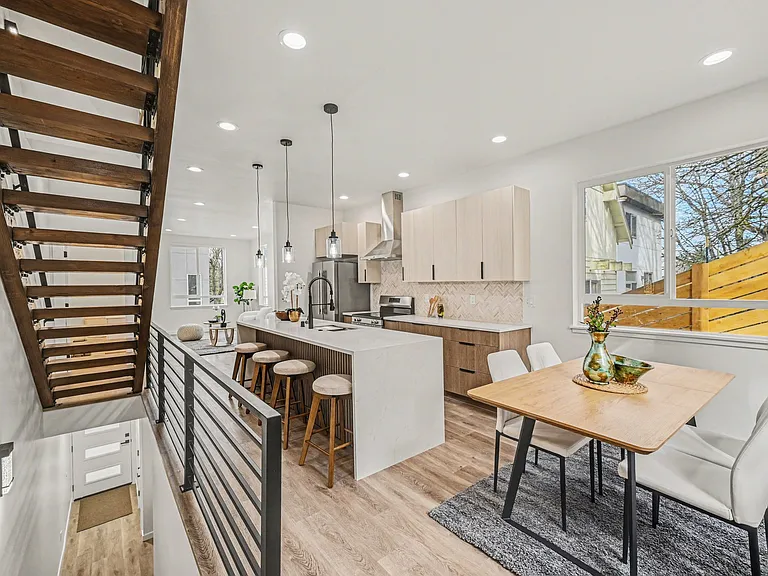Great open-concept main living area filled with natural light complete with wood stairs and other beautiful designer finishes.