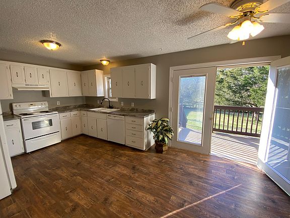 Private patio off kitchen overlooking a tree lined privacy fenced back yard