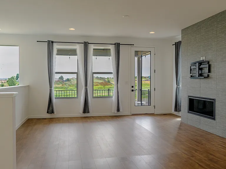 Comfortable living room featuring a central fireplace and natural light