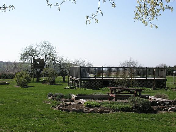 Backyard with pool, picnic area, and treehouse in rear 
