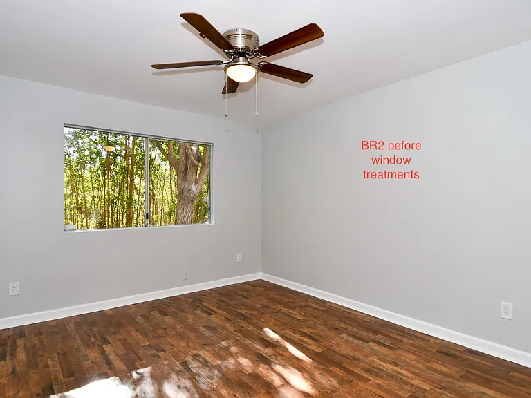 Bedroom 2 with includes ceiling fan. Vertical blinds have been installed.