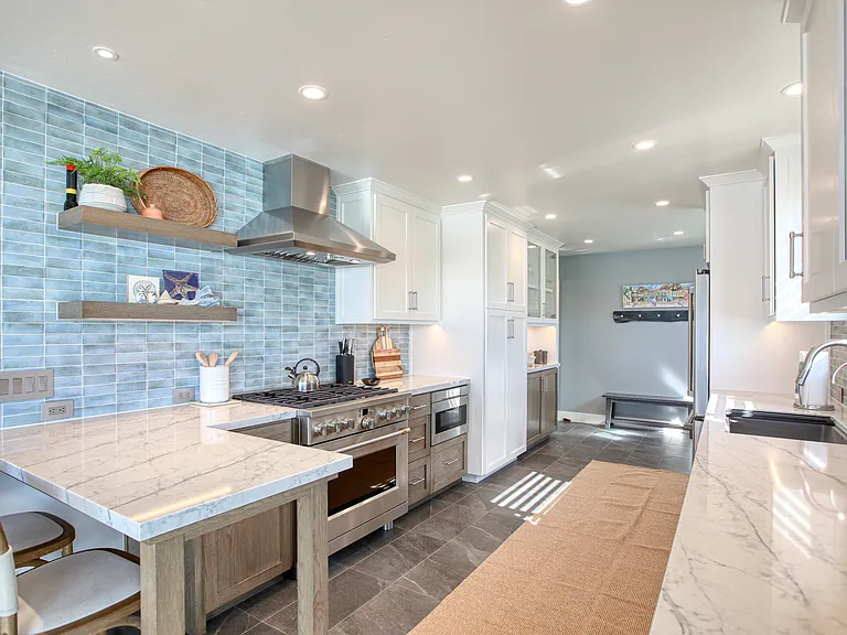 Coastal gourmet kitchen, completely remodeled in 2026 and equipped with chef-grade appliances, granite countertops, and custom cabinetry. Designed for both style and function, this bright and airy space is fully stocked with everything you need to prepare