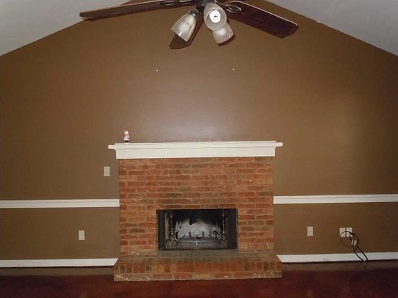 Living room with vaulted ceiling and brick fireplace