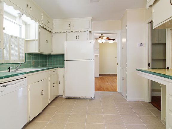 Kitchen with recently replaced tile floor, newer dishwasher and refrigerator. 
