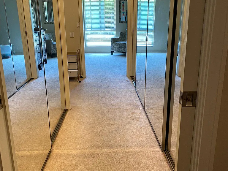 Hallway entry into master bedroom. Large glass sliding closets.