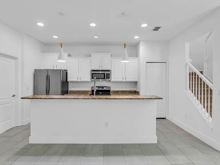 Spacious Kitchen seamlessly opens to Living Room and Dining Room and features granite, stainless steel appliances and large center island with breakfast bar.