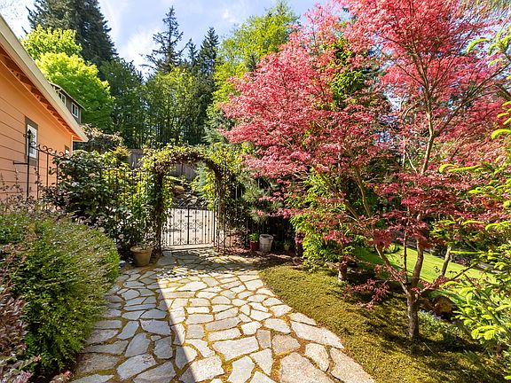 A stone walkway and covered arbor leading to the backyard.