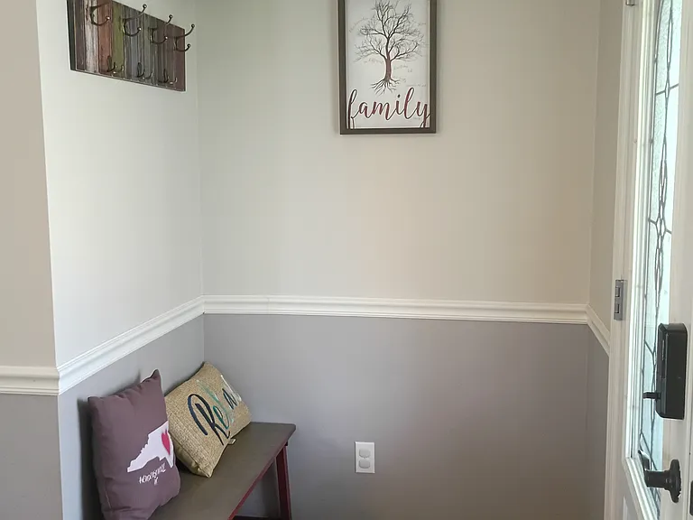 The front entrance provides a shoe corner and a coat rack for added convenience.