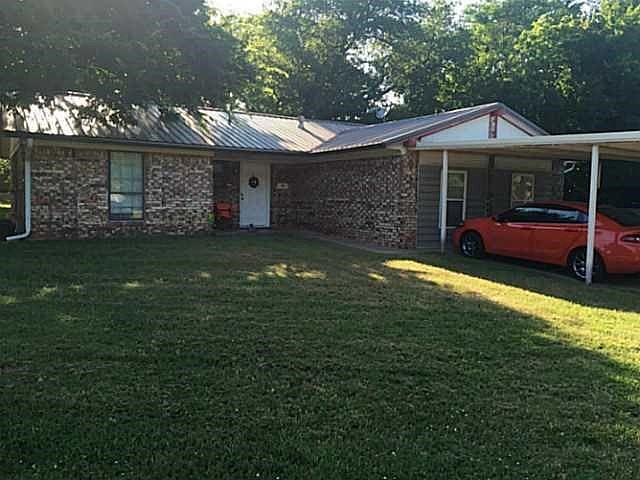Exterior Front. very large front yard with a carport.