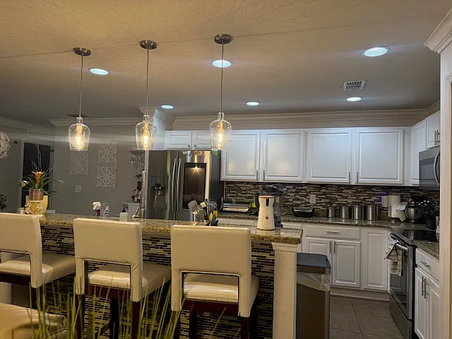Stunning open-concept kitchen with granite countertops, stainless steel appliances, and elegant lighting