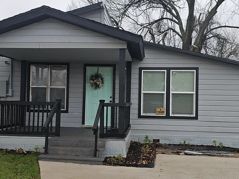 Completely renovated exterior featuring fresh siding, modern trim, and a welcoming covered porch